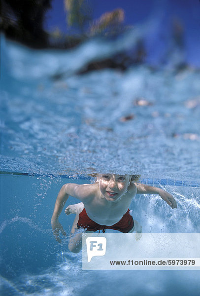 Kleinen Jungen schwimmen unter Wasser