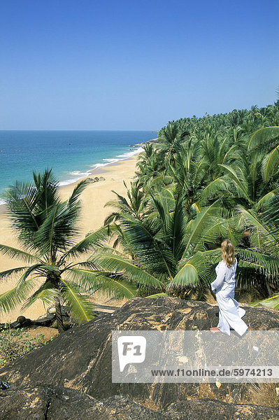 Frau suchen über Kokospalmen an den Strand  Kovalam  Kerala Zustand  Indien  Asien