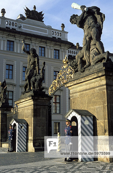 Two guards in front of the gate to Prague Castle  which has a titan statue on each of its two pillars  Hradcany  Prague  Czech Republic  Europe