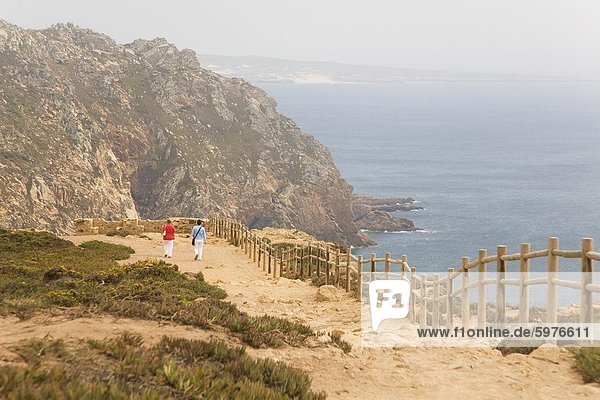 People walk along cliffs overlooking the Atlantic Ocean at Europe's most westerly point at Cabo da Roca  Portugal  Europe