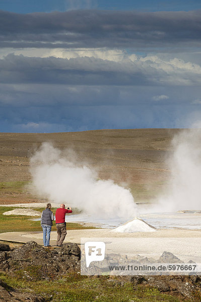 Tourists taking pictures of Oskurholshver (screaming spring)  famous hot spring at Hveravellir  Kjolur  Iceland  Polar Regions