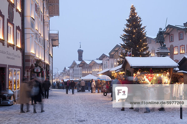Weihnachtsmarkt  Weihnachtsbaum mit Ständen und Menschenbei Marktstraße in der Dämmerung in die Spa Stadt von Bad Tölz  Bayern  Deutschland  Europa Weihnachtsmarkt