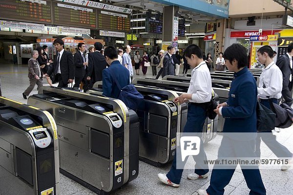 Passengers passing through automatic ticket wickets upon entering the JR Ueno railway station in Tokyo  Japan  Asia