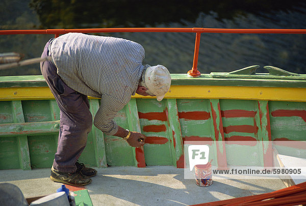 Mann  die Malerei der Innenseite eines Bootes auf Malta  Europa
