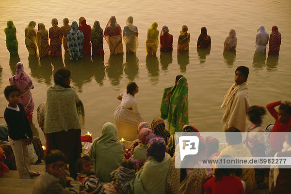 Hunderte von Frauen zu sammeln  in den Zeilen entlang Fluß Front  trotzt der Kälte  begrüßen die aufgehenden Sonnengott Surya  die Sonne anbeten Festival  Varanasi  Bundesstaat Uttar Pradesh  Indien  Asien