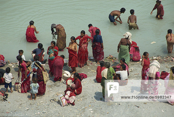 Ritual cleansing in Seti Khola  a tributary of the Ganges  for Nepali New Year  Pokhara  Nepa  Asia