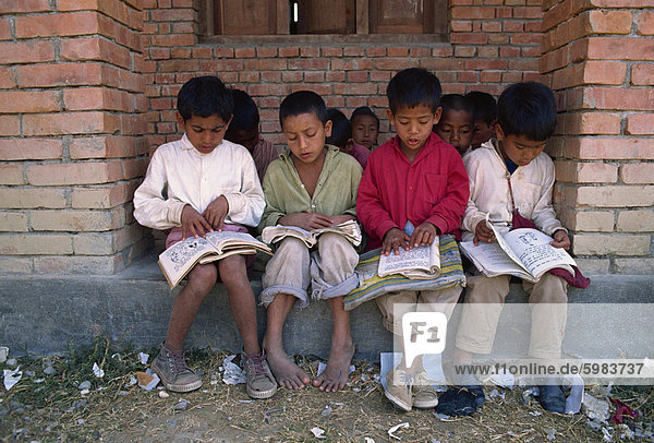 Portrait of a group of local boys reading books at the Save the Children funded school at Chataura  Nepal  Asia