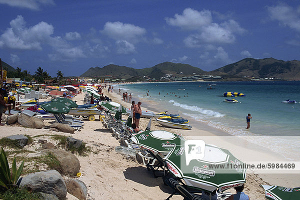 Touristen auf Liegestühlen unter Sonnenschirmen oder Sonnenschirme am Orient Beach  St. Maarten (St. Martin)  Inseln über dem Winde  Französische Antillen  Caribbean  Central America