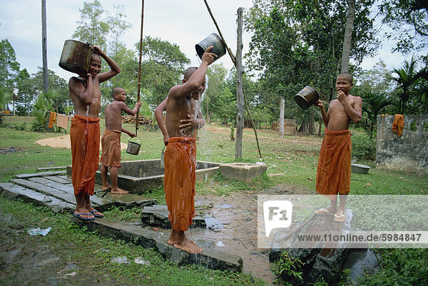 Anfänger Mönche Waschen am Abend in der Nähe von Roulos Tempel  Angkor Wat  Siem Reap  Kambodscha  Indochina  Südostasien  Asien