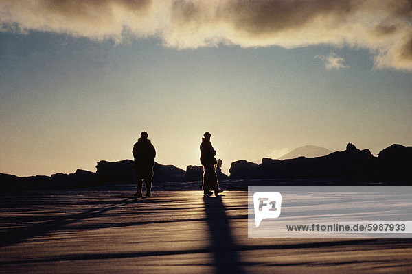 Two men out for a walk at sunrise  Antarctic  Polar Regions