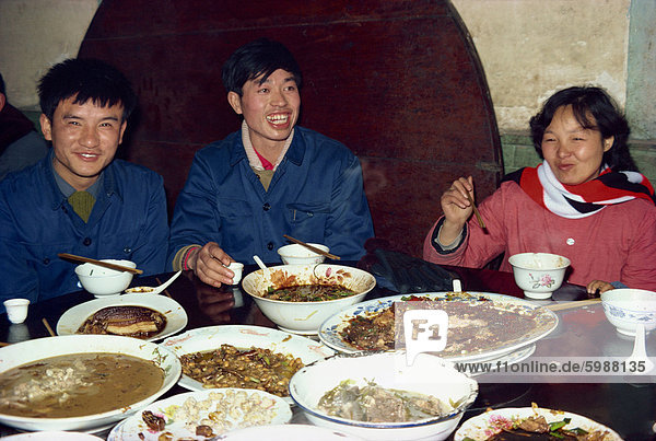Lokale Familie mit Schalen Essen bei einem Bankett in der chinesischen Provinz Sichuan  China  Asien