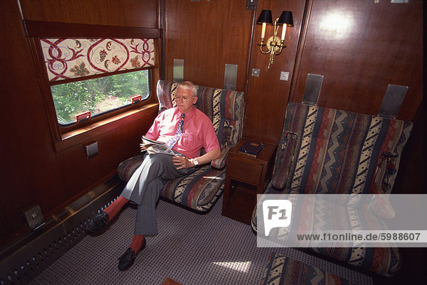 Passenger relaxing in his cabin on the American Orient Express train  travelling in the Southwest U.S.  United States of America  North America