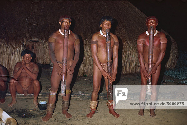 Eine Gruppe von Suempfe Indianern spielen Jabui Flöten nachts in Brasilien  Südamerika