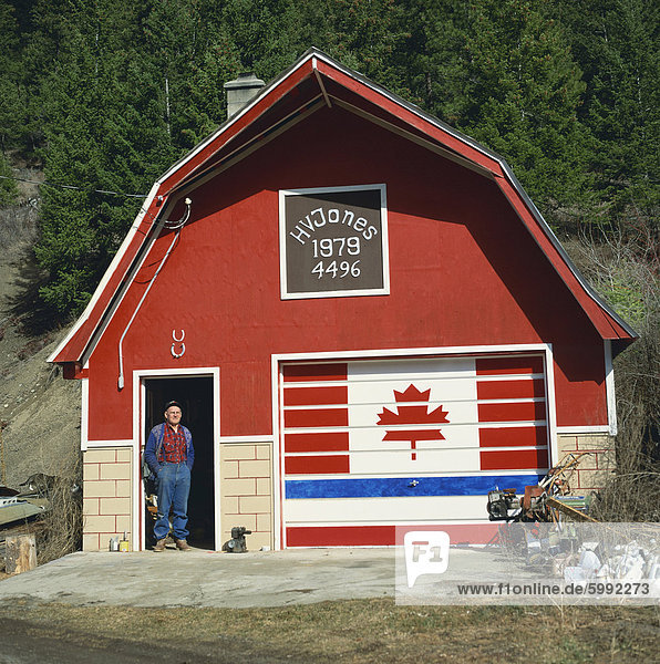 Ein Mann steht in der Tür unter zwei glückliche Hufeisen  neben einer Tür gemalt mit der kanadischen Flagge  bei einem patriotischen Workshop in der Nähe von Vernon  British Columbia  Kanada  Nordamerika
