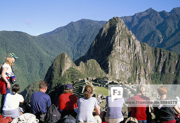 Tourists looking out over Machu Picchu  UNESCO World Heritage Site  Peru  South America