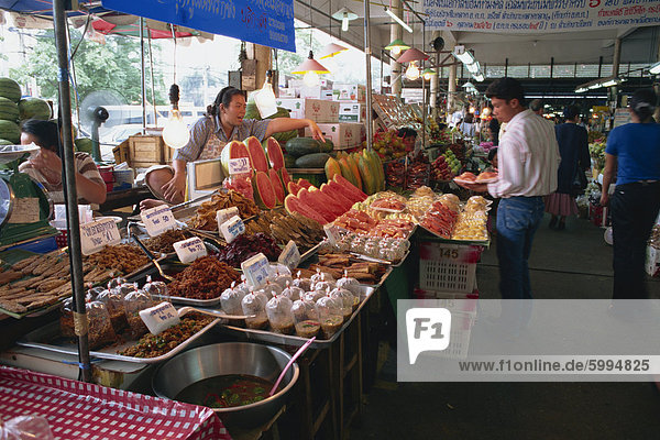 Ein Ladenbesitzer auf Obst auf einem der Nahrung zeigen Ständen am Wochenende Markt in Bangkok  Thailand  Südostasien  Asien