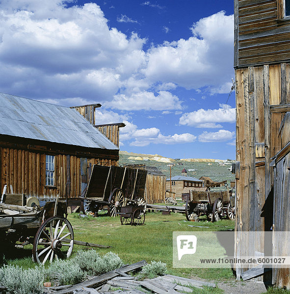 Wooden buildings and carts at Bodie  Ghost Town  Bodie State Historic Park  California  United States of America (USA)  North America