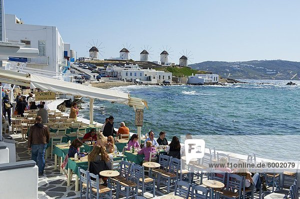 Cafe bar on the sea side with the five windmills (Kato Mili) beyond  Little Venice  Mykonos Town  Chora  Mykonos Island  Cyclades  Greek Islands  Greece  Europe