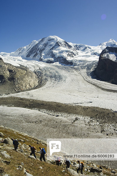 Hikers nearing ice flow of the Monte Rosa glacier  Zermatt Alpine Resort  Valais  Switzerland  Europe
