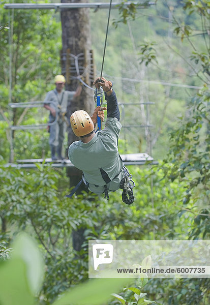 Mann auf einem Baldachin Informationsschalter Zipline im Regenwald  Pacuare Fluss  Turrialba  Costa Rica  Mittelamerika