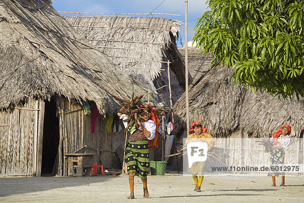 Kuna women carrying wood through village  Wichub-Wala Island  San Blas Islands  Comarca de Kuna Yala  Panama  Central America