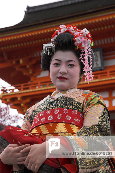 Geisha in traditional dress posing in front of main torii  Kiyomizudera temple  Kyoto  Kansai  Honshu  Japan  Asia