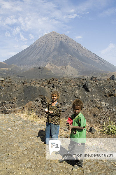 Child vendors selling souvenirs  with the Pico de Fogo volcano in the background  Fogo (Fire)  Cape Verde Islands  Africa