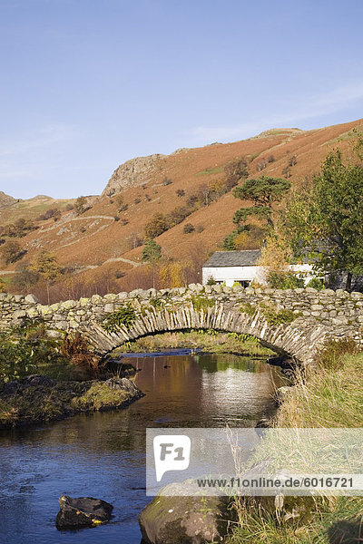 Alte steinerne Packhorse Brücke über den Watendlath Beck im malerischen Dorf im Herbst Watendlath Lake District-Nationalpark Cumbria England Vereinigtes Königreich Europa