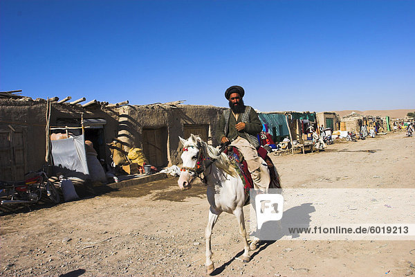 Man riding horse along road in small village  between Herat and Maimana  after Bala Murghah  Afghanistan  Asia