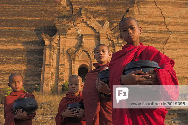 Novice Monks holding alms bowls at Mingun Paya  Mingun  Mandalay  Myanmar (Burma)  Asia