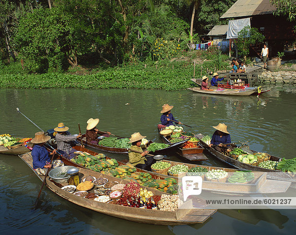 Frauen in Strohhüten in Booten geladen mit Obst  Gemüse  Lebensmittel  auf einem schwimmenden Markt auf einem Kanal in Thailand  Südostasien  Asien
