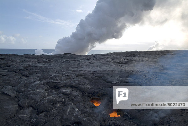 Oberlicht  Blick durch gekühlte Lava bis geschmolzene Lava unten  mit Federn des Dampf als Lava erreicht das Meer hinaus  Kilauea-Vulkan  Hawaii Volcanoes Nationalpark  UNESCO Weltkulturerbe  Insel Hawaii (Big Island'  Hawaii  Vereinigte Staaten von Amerika  Nordamerika
