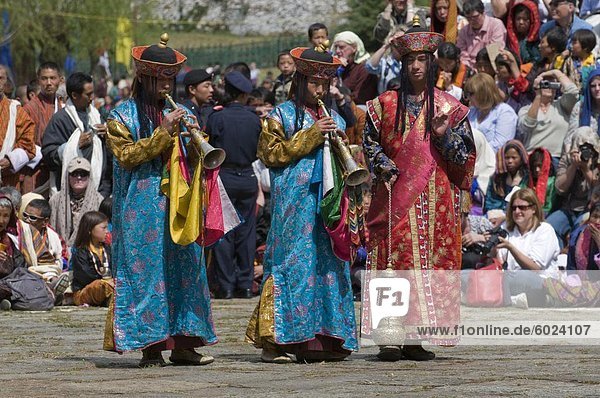 Buddhists playing the flute at religious festivity  Paro Tsechu  Paro  Bhutan  Asia