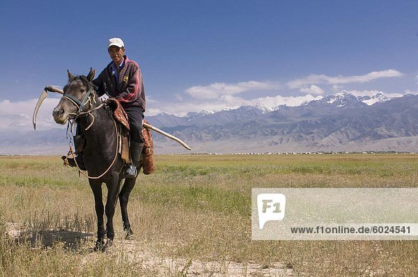 Kyrgyz man on his way to harvest  Torugat Pass  Kyrgyzstan  Central Asia  Asia