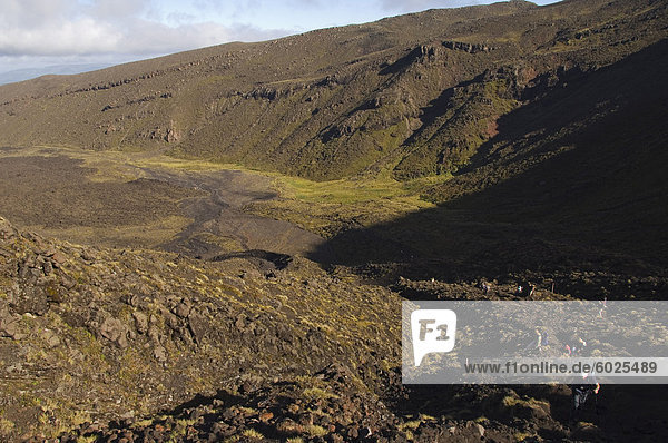 Hikers walking through a lava field on the Tongariro Crossing  Tongariro National Park  the oldest national park in the country  UNESCO World Heritage Site  Taupo Volcanic Zone  North Island  New Zealand  Pacific