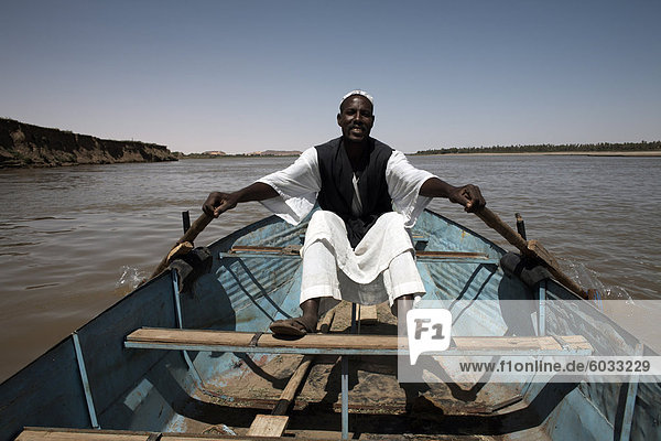 A boatman rows along the Nile river near Karima  Sudan  Africa