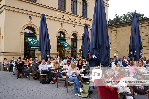 Leute sitzen außerhalb Café Tambosi  in der Nähe von Hofgarten und die Theatiner-Kirche  München  Bayern  Deutschland  Europa