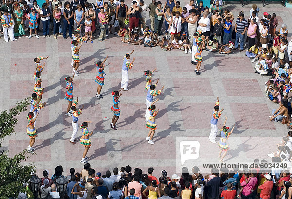 Schulkinder in ausgefallenen Kostümen tanzen auf einem Festival in Parque Cespedes  Santiago De Cuba  Kuba  Westindische Inseln  Mittelamerika