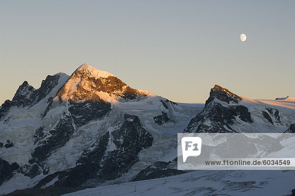 Mond steigt über das Klein Matterhorn  3883m und Breithorn 4164m Berge  Alpine Resort Zermatt  Wallis  Schweiz  Europa