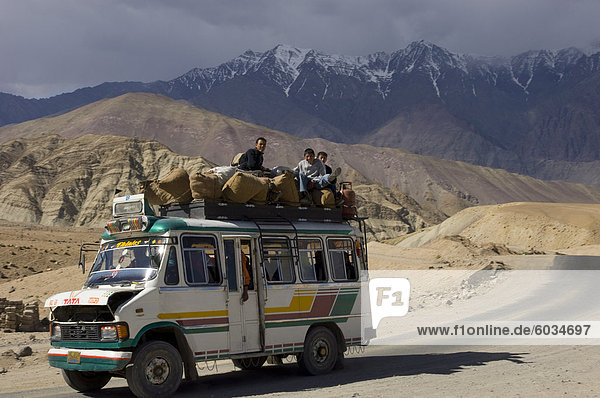 Geladen Mini-Bus mit halb offenen Motor Deckel und Leute sitzen auf dem Dach auf der Straße zwischen Leh und Alchi  Indus-Tal  Ladakh  Indien  Asien