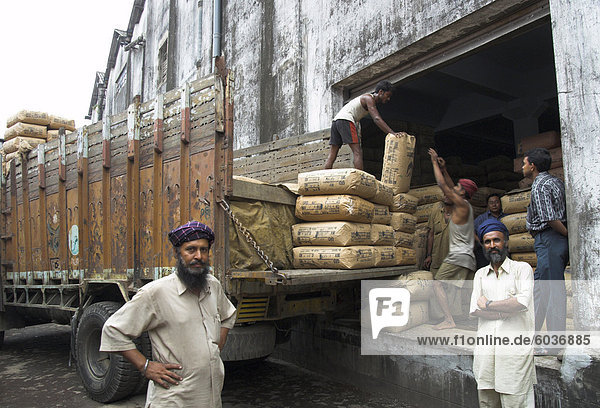 LKW-Fahrer posieren vor Tee Säcke gerade entladen in Carrit Moran & Unternehmens Tee lagern bei Kolkata Port  Kolkata  Westbengal Zustand  Indien  Asien