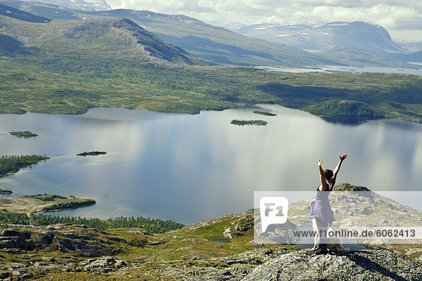 Tourist on top of rock overlooking lake