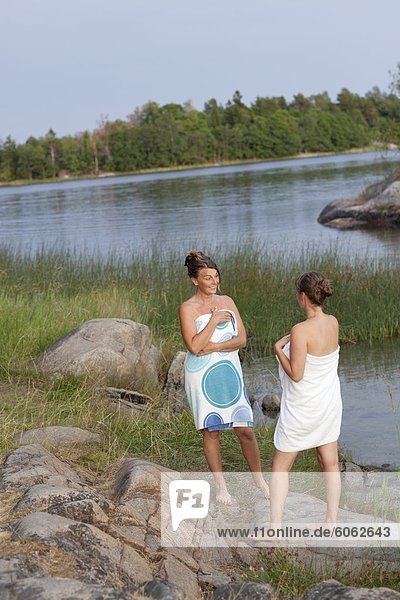 Zwei Frauen umwickelt Handtücher am Strand