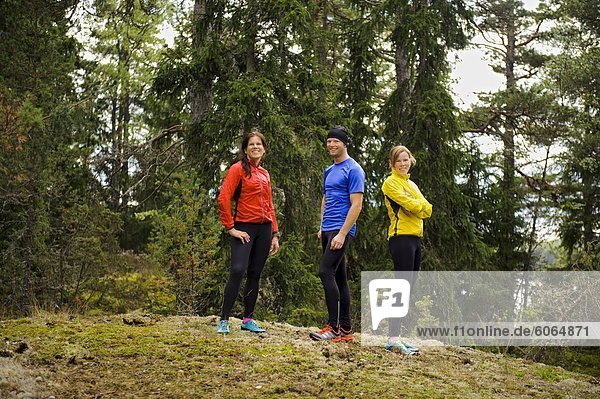 Three athletes standing in forest
