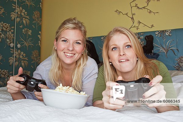 Zwei junge Frauen Video-Spiel im Schlafzimmer