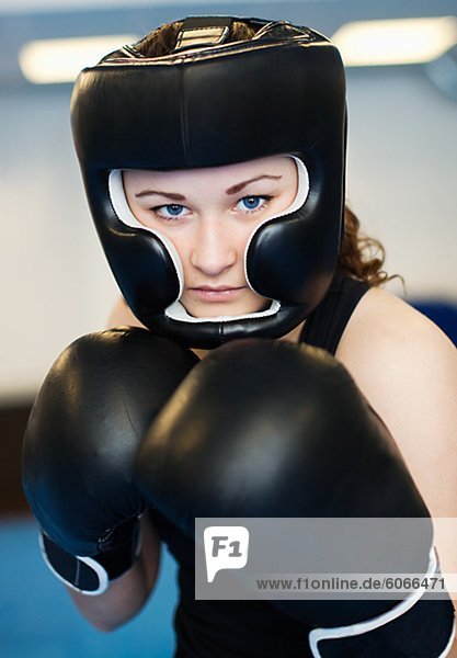Portrait of young woman wearing boxing gloves