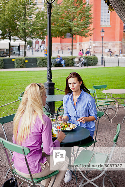 Zwei Frauen sitzen im Café im freien