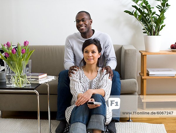 Porträt des Paares im Wohnzimmer sitzen und Fernsehen