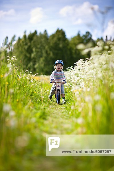 Junge Radfahren in Wiese