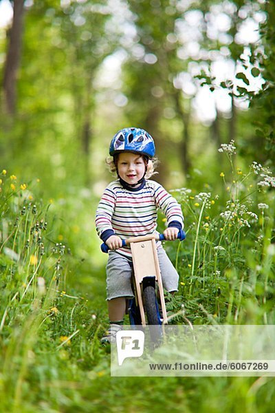 Boy cycling in meadow